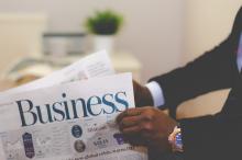 photo of business man holding a business newspaper